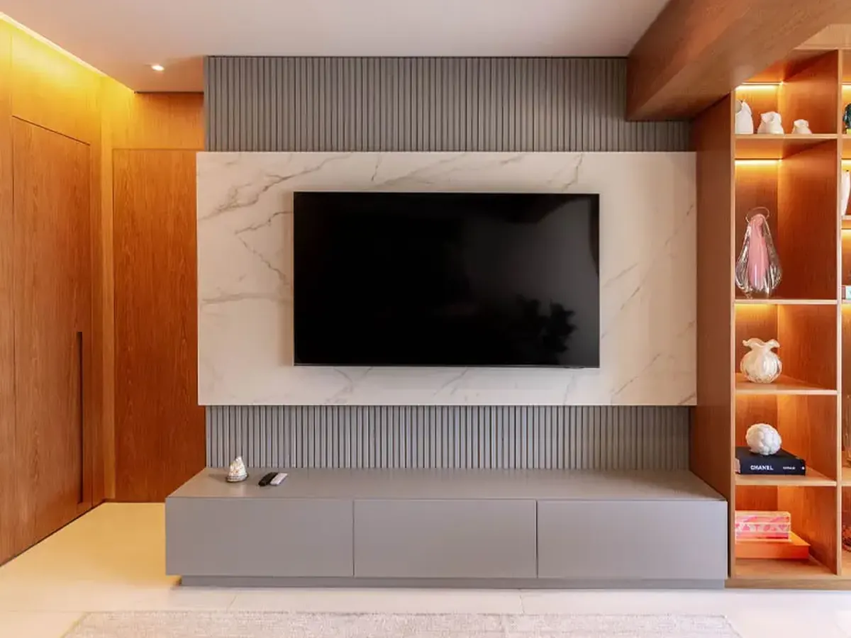 Painel de TV e rack laqueados em cinza fosco, integrados à marcenaria da sala